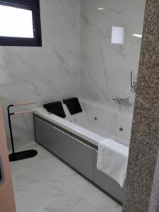 un bagno bianco con vasca e lavandino di Vonando a Geres