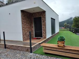 uma casa com um alpendre com um relvado verde em Vonando em Gerês