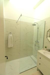 La salle de bains est pourvue d'une douche avec une porte en verre. dans l'établissement Apartment MiraMare on the beach, à Split