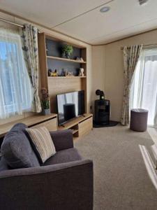 een woonkamer met een bank en een televisie bij W16 in Paignton