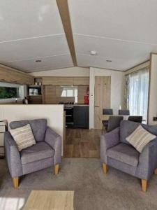 uma sala de estar com duas cadeiras e uma cozinha em W16 em Paignton