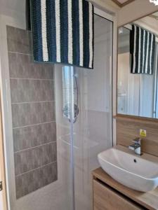 uma casa de banho com um chuveiro e um lavatório branco em W16 em Paignton