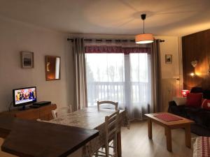 ein Wohnzimmer mit einem Tisch, einem Sofa und einem TV in der Unterkunft Appartement Megève, 1 pièce, 4 personnes - FR-1-597-14 in Megève