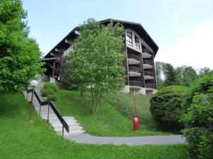 a building with stairs and a tree in front of it at Studio avec Piscine Chauffée, Tennis & Balcon - 4 Couchages à Megève - FR-1-597-14 in Megève