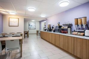 a restaurant with a counter and tables and chairs at Microtel Inn & Suites by Wyndham Southern Pines Pinehurst in Southern Pines