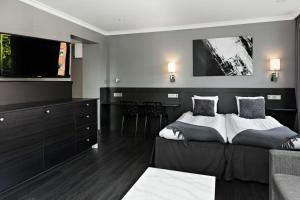 a bedroom with two beds and a flat screen tv at Hotel Allén - Sure Hotel by Best Western Allen in Gothenburg