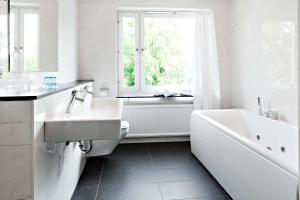a white bathroom with a tub and a sink at Hotel Allén - Sure Hotel by Best Western Allen in Gothenburg