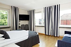 a bedroom with a large bed and two windows at Hotel Allén - Sure Hotel by Best Western Allen in Gothenburg