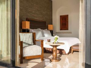 منتجع وسبا موڤنبيك البحر الميت في السويمة: غرفة نوم بسرير وكرسي وطاولة