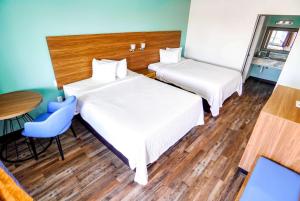 a hotel room with two beds and a table at Days Inn by Wyndham Victorville in Victorville