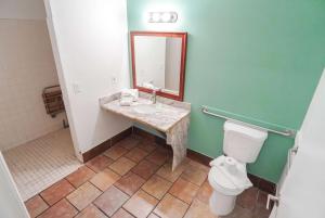 a bathroom with a toilet and a sink and a mirror at Days Inn by Wyndham Victorville in Victorville