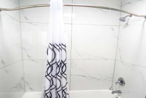 a shower with a black and white shower curtain at Days Inn by Wyndham Victorville in Victorville