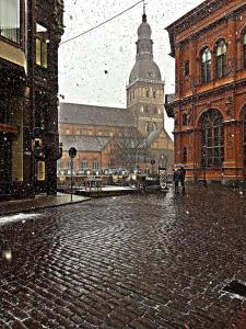 a person walking down a street in the snow at Accommodation in the historical center of Riga in Riga