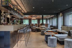 un ristorante con bar con sgabelli e tavoli di Hotel Christof a Monguelfo