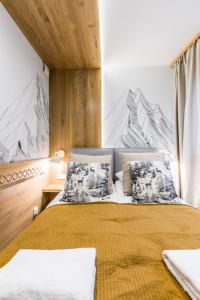 a bedroom with a bed with a yellow bedspread at Apartament Atena in Zakopane