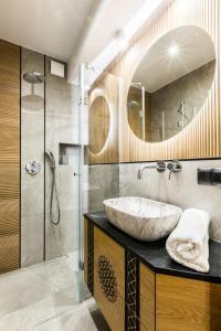 a bathroom with a sink and a shower and a mirror at Apartament Atena in Zakopane