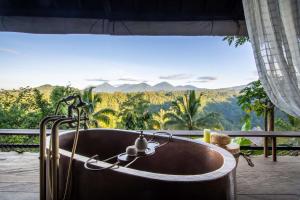 a bath tub with a view of the mountains at Buahan, a Banyan Tree Escape in Payangan