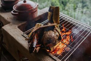 a piece of meat being grilled on a grill at Buahan, a Banyan Tree Escape in Payangan