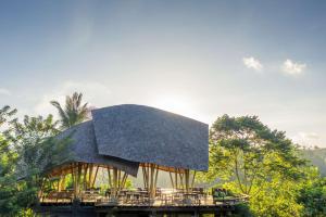 a building with a roof with tables and chairs at Buahan, a Banyan Tree Escape in Payangan