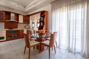 uma cozinha com uma mesa de vidro e cadeiras e uma janela em Casa di Vasia em Gennadi