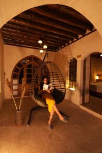 a woman sitting in a swing in a room at CEVHER KONAĞI in Halfeti