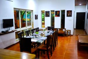 uma sala de jantar com uma mesa longa e cadeiras em EliteHotels and Resorts Pvt Ltd em Alibaug