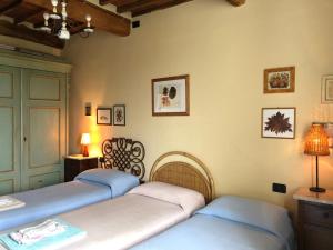 a room with three beds and a lamp on a wall at Casa Marcè a "Sonno" in Porcari