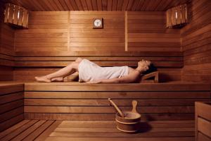 Eine Frau liegt in einer Sauna in der Unterkunft Hotel Paris in Opatija