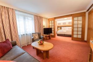 een hotelkamer met een bank en een bed bij Hotel Ulli in Zürs am Arlberg
