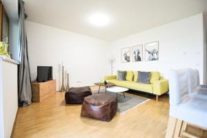 ein Wohnzimmer mit einem gelben Sofa und einem TV in der Unterkunft Toferer Textil in Eben im Pongau