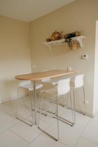 a dining room table with white chairs around it at In De Witte Engel in Lanaken