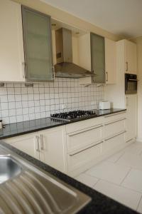 a kitchen with white cabinets and a stove top oven at In De Witte Engel in Lanaken