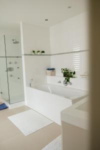 La salle de bains blanche est pourvue d'une baignoire et d'un lavabo. dans l'établissement In De Witte Engel, à Lanaken