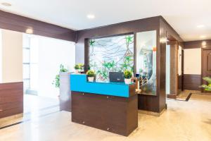 a lobby with a reception desk with a aquarium at Octave Fairmont Suites in Bangalore