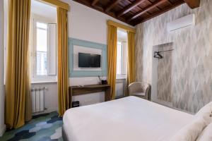 a bedroom with a white bed and a tv at 59 Steps Trevi in Rome