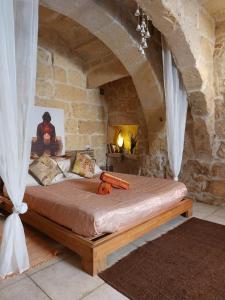 ein Schlafzimmer mit einem Bett in einer Steinmauer in der Unterkunft bedroom buddha external bathroom in Kerċem