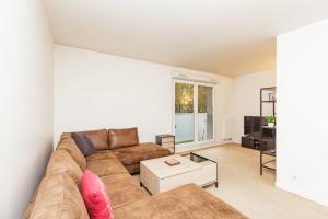 a living room with a couch and a coffee table at Bright 68 m2 apartment near the Stade de France in Aubervilliers