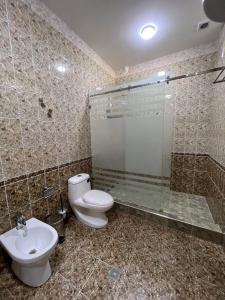 a bathroom with a toilet and a shower and a sink at Stariy Marokand in Samarkand