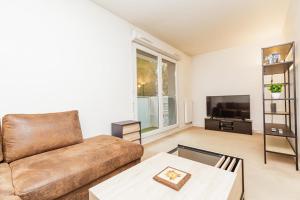 een woonkamer met een bank en een tv bij Bright 68 m2 apartment near the Stade de France in Aubervilliers
