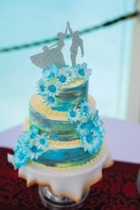 a wedding cake with blue flowers on a table at VARU by Atmosphere - Premium All Inclusive with Free Transfers in North Male Atoll
