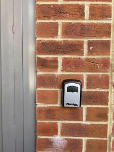 a soap dispenser on a brick wall at Fully Detached Studio Annexe with Double Bed for 2 & Sofa Bed for 2 in Cambourne