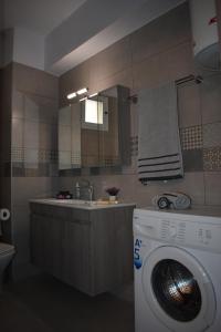 uma casa de banho com uma máquina de lavar roupa e um lavatório em Domenica Studios 2 em Tessalônica