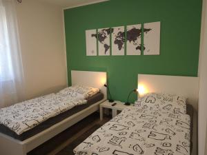 1 Schlafzimmer mit 2 Betten und einer grünen Wand in der Unterkunft Haus KüstenBrise - Urlaub mit Hund an der Küste mit eigenen Garten, Sauna und gemütlichen Kaminfeuer in Schweiburg