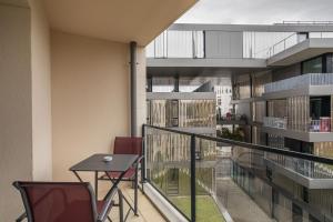 - un balcon avec une table et des chaises dans un bâtiment dans l'établissement Le Bienveillant - T3 proche Jardin des Plantes, à Nantes
