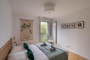 - une chambre avec un grand lit et une fenêtre dans l'établissement Le Bienveillant - T3 proche Jardin des Plantes, à Nantes