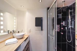 La salle de bains est pourvue d'un lavabo et d'une douche. dans l'établissement Le Crucy - T2 avec Parking, à Nantes