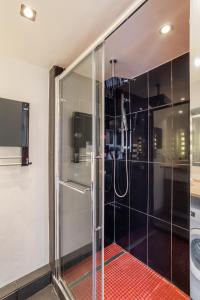 La salle de bains est pourvue d'une douche avec une porte en verre. dans l'établissement Le Crucy - T2 avec Parking, à Nantes