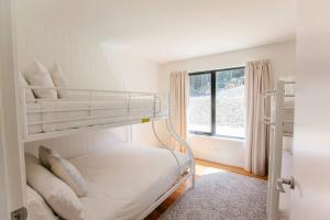 a bedroom with two bunk beds and a window at Bush and Beach Family Retreat in Adventure Bay