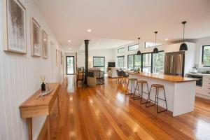 una cucina e un soggiorno con pavimenti in legno e bancone di Bush and Beach Family Retreat ad Adventure Bay