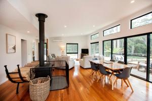 a living room with a fireplace and a table and chairs at Bush and Beach Family Retreat in Adventure Bay